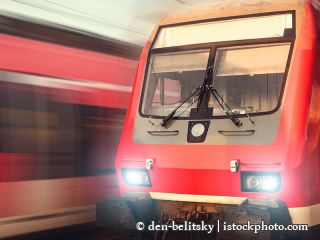 538597602-Wunderschöne Bahnhof mit modernen roten Pendlerzug während dem Sonnenuntergang-den