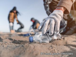 179252601- Freiwilliger Mann sammelt Müll am Strand. Ökologiekonzept